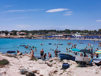 People at beach against sky