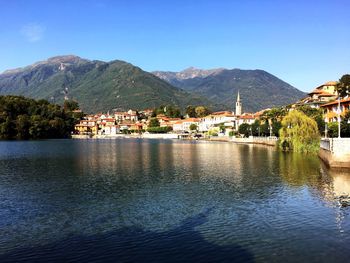 Scenic view of lake by buildings against sky