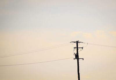 Low angle view of power lines against sky