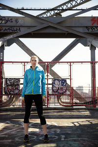 Female athlete standing at williamsburg bridge pedestrian walkway