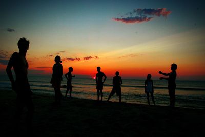 Silhouette of people at beach during sunset