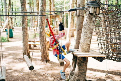 Low angle view of girl on swing in playground