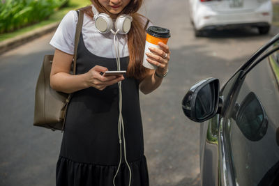 Young woman holding car