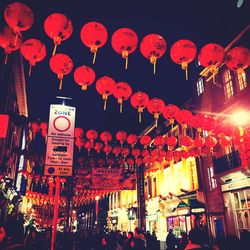 Illuminated lanterns hanging against sky at night