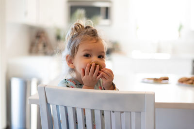 Portrait of cute girl eating at home