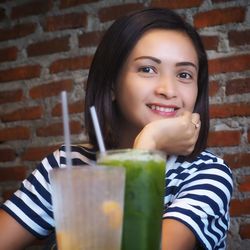 Portrait of smiling woman having drink in restaurant
