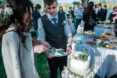 Couple cutting cake during wedding ceremony