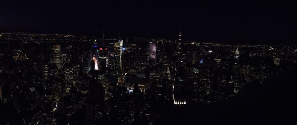 Low angle view of illuminated cityscape against sky at night