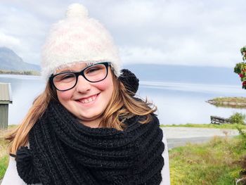 Portrait of smiling young woman against sky during winter