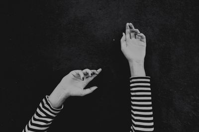 Close-up of hand holding hands against black background