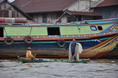 People on boat moored in water