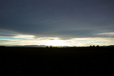 Scenic view of silhouette field against sky during sunset