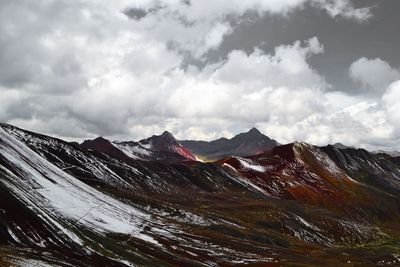 Scenic view of snowcapped mountains against cloudy sky