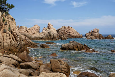 Rocks at beach against sky