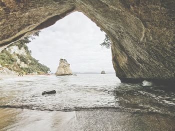 Rock formation on sea shore against sky