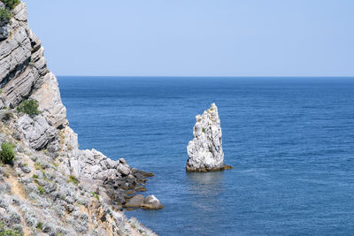 Rocks in the sea against the blue sky