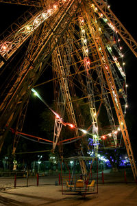 Low angle view of illuminated ferris wheel against sky at night