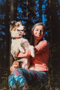 Candid portrait of a female athlete with her running and hiking partner, an australian shepherd dog