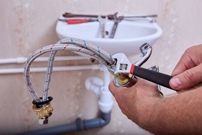 Cropped hand of person repairing pipe