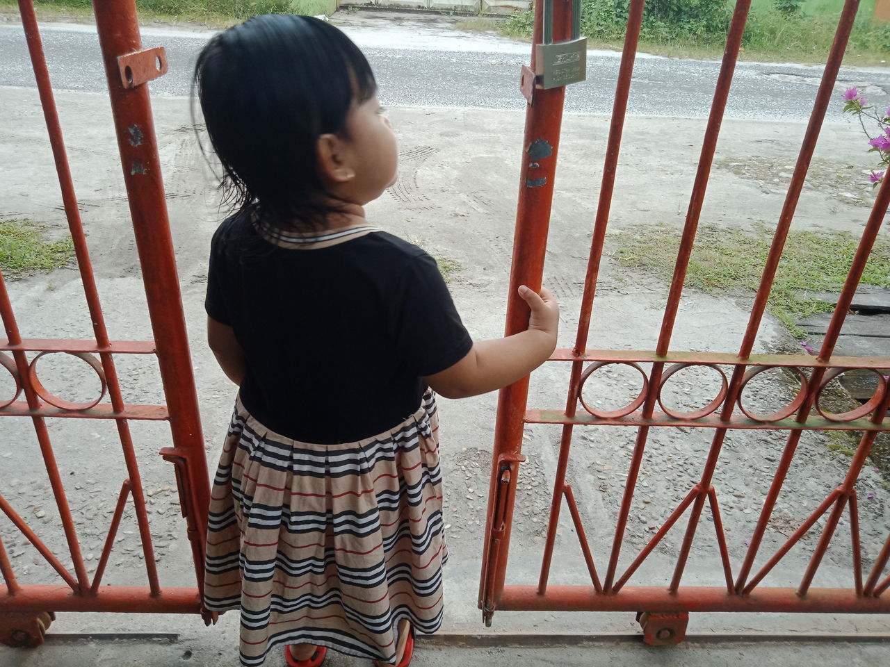 FULL LENGTH OF BOY LOOKING AT RAILING