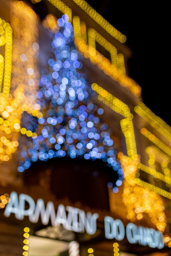 illuminated, night, decoration, glowing, christmas lights, christmas decoration, no people, celebration, lighting equipment, defocused, christmas, light - natural phenomenon, architecture, built structure, low angle view, focus on foreground, electricity, holiday, building exterior, lens flare, light, christmas market