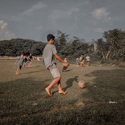 Friends playing soccer in garden