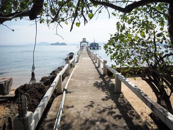 Footpath by sea against sky