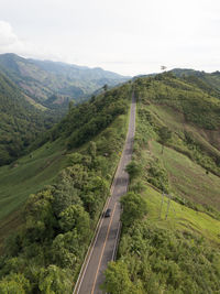 High angle view of road amidst green landscape against sky