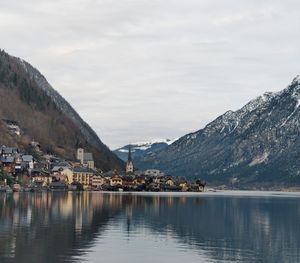Scenic view of lake by buildings against sky