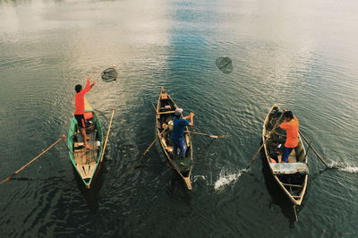 Rear view of men boating on lake
