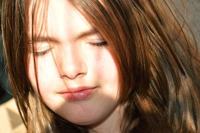 Photo portrait of a serene young girl enjoying the sunlight