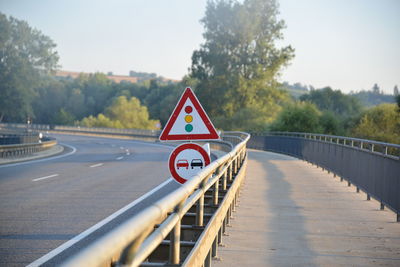 Road signs on bridge against clear sky