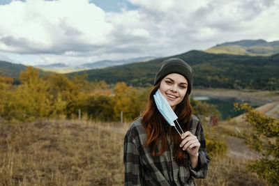 Smiling young woman looking away against mountains