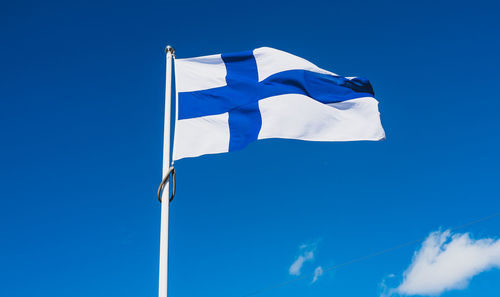 Low angle view of flag against blue sky