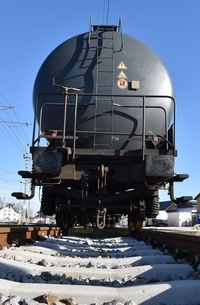 Train on snow covered railroad tracks against clear sky