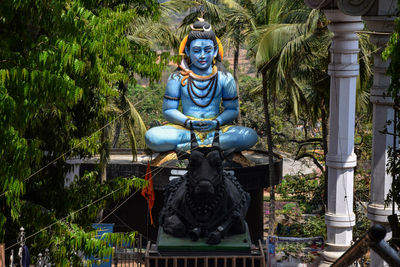 Statue of buddha against plants