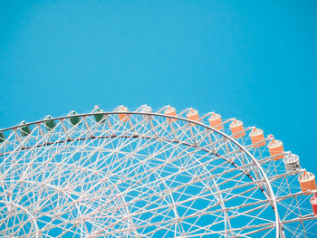 Low angle view of ferris wheel against blue sky