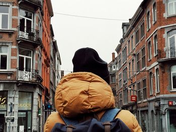 Rear view of man in city against buildings