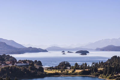 Scenic view of sea and mountains against clear sky