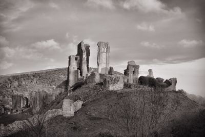 Abandoned built structure on landscape against sky