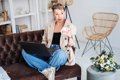 Beautiful hipster woman in casual cloth using laptop at home. cheerful woman using laptop