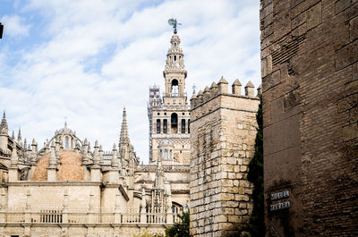Low angle view of bell tower against cloudy sky