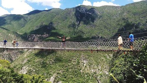 People standing by railing against mountains