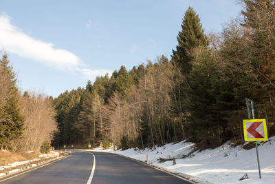 Road amidst trees against sky