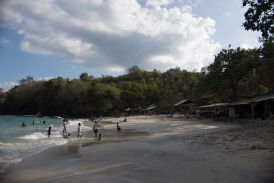 People at beach against sky