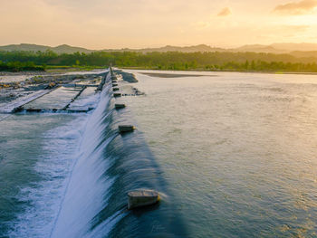 Scenic view of river against sky during sunset