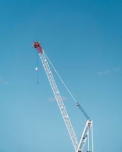 Low angle view of crane against blue sky