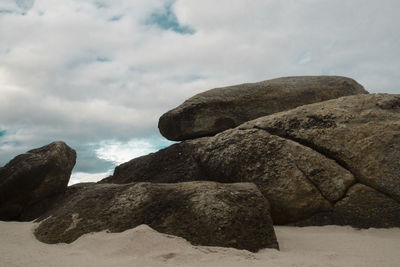 Low angle view of rock formation on beach against sky
