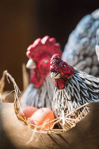 Clay hen and egg in wood basket.