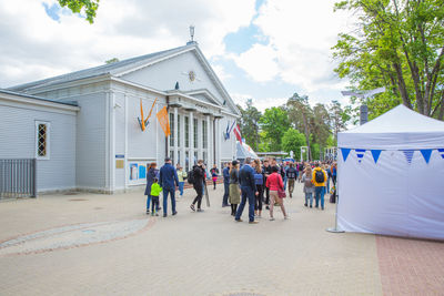 People in front of building against sky